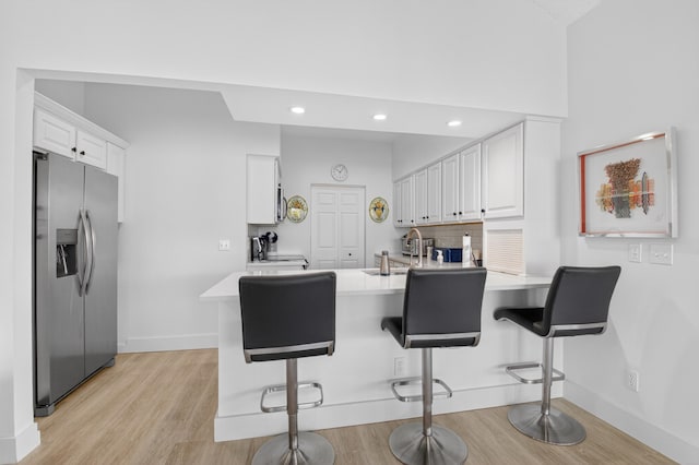 19349 Sabal Lake Dr Unit 5046, Boca Raton, FL 33434 - kitchen with stainless steel refrigerator with ice dispenser, a peninsula, light wood finished floors, white cabinetry, and light countertops