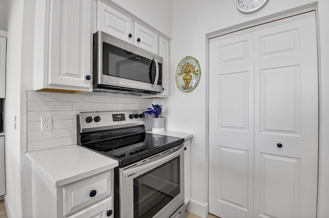 19349 Sabal Lake Dr Unit 5046, Boca Raton, FL 33434 - kitchen with stainless steel appliances, backsplash, white cabinetry, and light stone counters