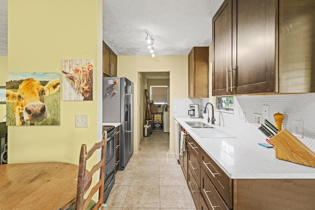 849 SE Celtic Ave, Port Saint Lucie, FL 34983 - kitchen featuring light countertops, backsplash, light tile patterned floors, appliances with stainless steel finishes, and a textured ceiling