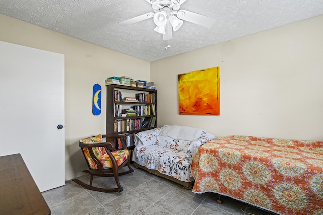 849 SE Celtic Ave, Port Saint Lucie, FL 34983 - bedroom with a textured ceiling, tile patterned flooring, and ceiling fan