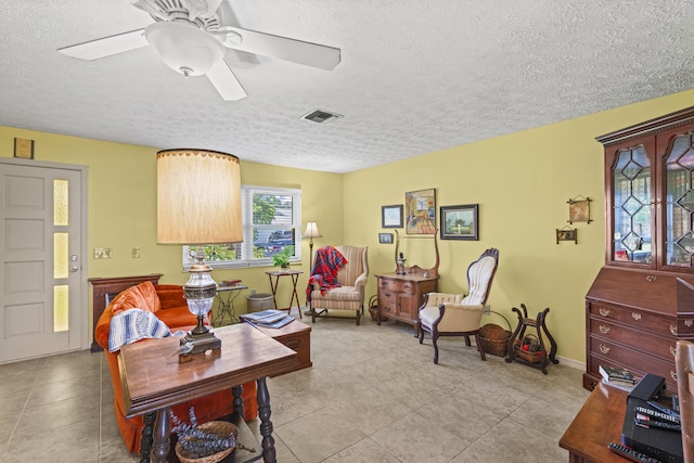 849 SE Celtic Ave, Port Saint Lucie, FL 34983 - living room with a textured ceiling, ceiling fan, and light tile patterned flooring