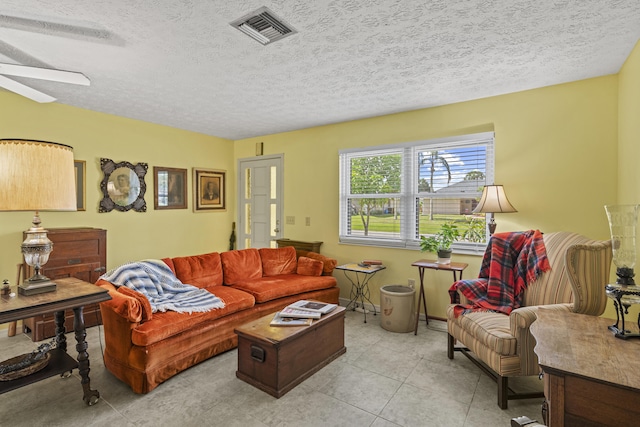 849 SE Celtic Ave, Port Saint Lucie, FL 34983 - living room featuring ceiling fan, a textured ceiling, and light tile patterned floors