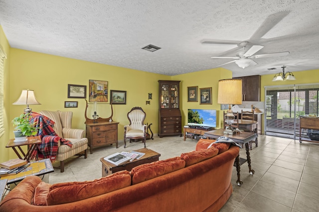 849 SE Celtic Ave, Port Saint Lucie, FL 34983 - living area with a ceiling fan, light tile patterned floors, a textured ceiling, and a chandelier