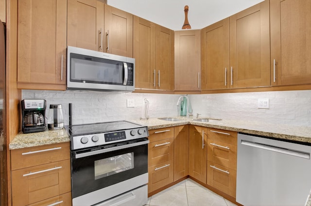 9927 Boca Gardens Trl Unit A, Boca Raton, FL 33496 - kitchen featuring stainless steel appliances, light stone counters, tasteful backsplash, and brown cabinets