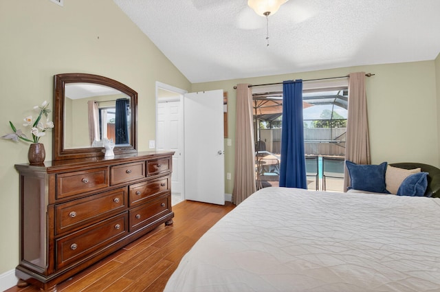 9927 Boca Gardens Trl Unit A, Boca Raton, FL 33496 - bedroom featuring vaulted ceiling, access to outside, wood finished floors, a textured ceiling, and a ceiling fan