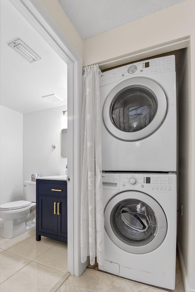 9927 Boca Gardens Trl Unit A, Boca Raton, FL 33496 - laundry room featuring stacked washer / drying machine and light tile patterned flooring