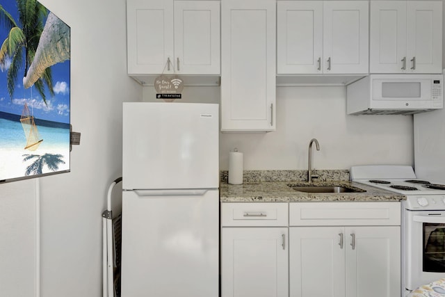 774 SE Ablett Ln, Port Saint Lucie, FL 34984 - kitchen featuring white appliances, white cabinetry, and light stone countertops