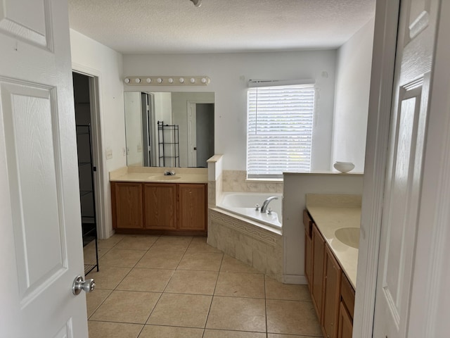 1965 SW Bellevue Ave, Port Saint Lucie, FL 34953 - full bathroom with two vanities, a garden tub, tile patterned floors, and a textured ceiling