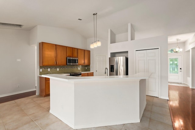 1901 SW Diamond St, Port Saint Lucie, FL 34953 - kitchen featuring stainless steel appliances, brown cabinets, tasteful backsplash, light countertops, and vaulted ceiling