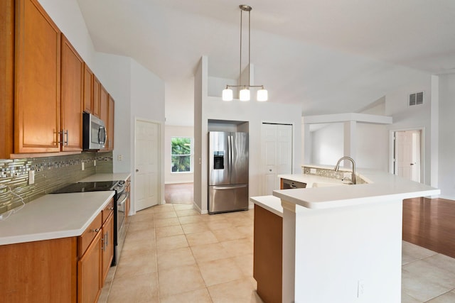 1901 SW Diamond St, Port Saint Lucie, FL 34953 - kitchen with stainless steel appliances, decorative backsplash, light countertops, brown cabinets, and high vaulted ceiling