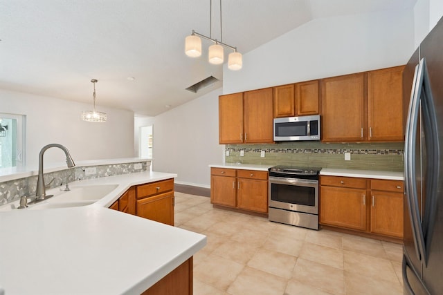 1901 SW Diamond St, Port Saint Lucie, FL 34953 - kitchen featuring appliances with stainless steel finishes, vaulted ceiling, decorative backsplash, brown cabinets, and light countertops