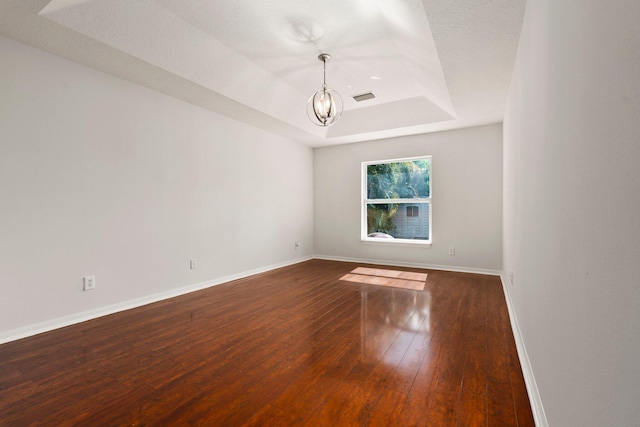 1901 SW Diamond St, Port Saint Lucie, FL 34953 - unfurnished room featuring a chandelier, a raised ceiling, and dark wood-type flooring