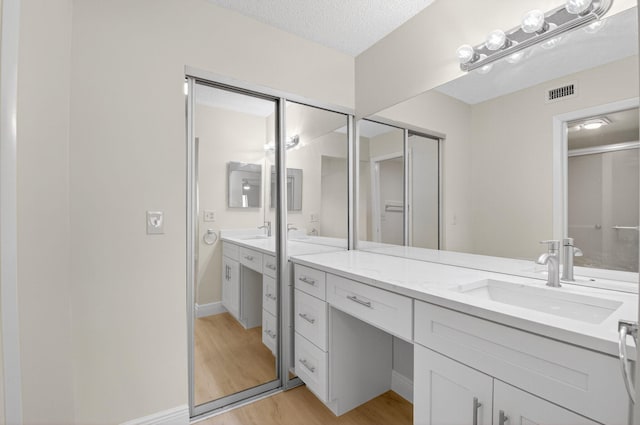 5574 Witney Dr Unit 104, Delray Beach, FL 33484 - bathroom featuring vanity, wood finished floors, and a textured ceiling