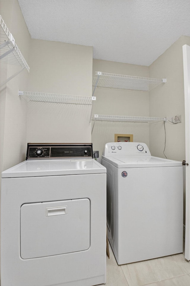 5574 Witney Dr Unit 104, Delray Beach, FL 33484 - washroom with washing machine and clothes dryer and light tile patterned floors