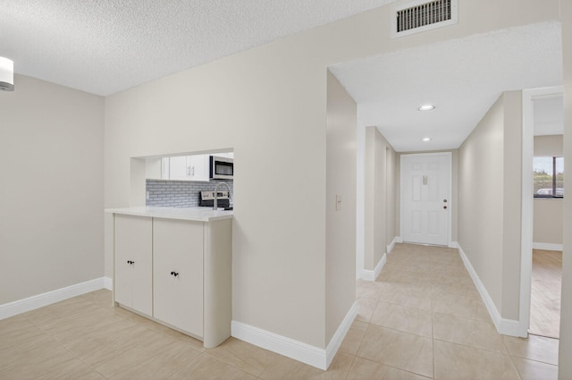 5574 Witney Dr Unit 104, Delray Beach, FL 33484 - corridor featuring light tile patterned floors, a textured ceiling, and recessed lighting