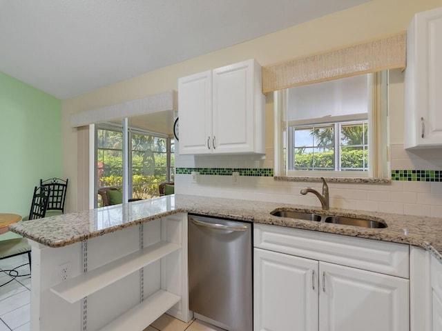 374 NW Sherry Ln, Port Saint Lucie, FL 34986 - kitchen featuring stainless steel dishwasher, white cabinetry, tasteful backsplash, light stone countertops, and a peninsula