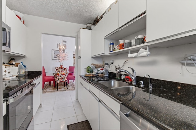 14085 Nesting Way Unit C, Delray Beach, FL 33484 - kitchen featuring appliances with stainless steel finishes, white cabinetry, dark stone counters, a textured ceiling, and light tile patterned flooring