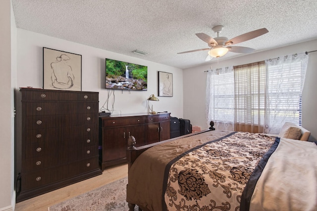 14085 Nesting Way Unit C, Delray Beach, FL 33484 - bedroom with light wood-type flooring, a textured ceiling, and a ceiling fan