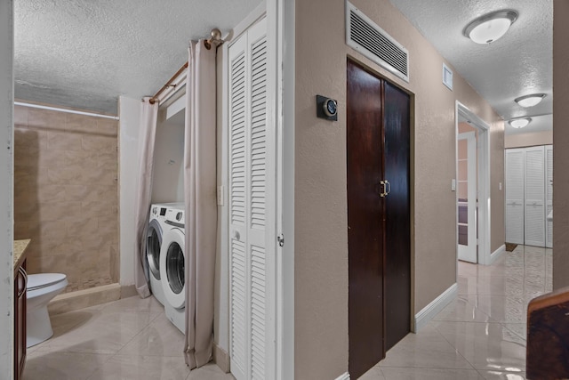 7670 NW 79th Ave Unit O3, Tamarac, FL 33321 - laundry area featuring a textured ceiling, light tile patterned flooring, and washer / clothes dryer