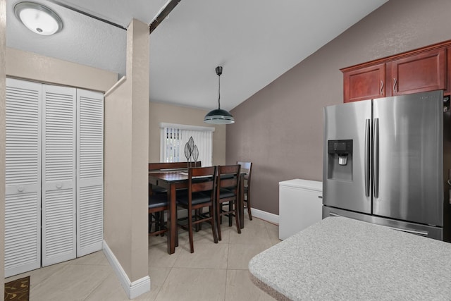 7670 NW 79th Ave Unit O3, Tamarac, FL 33321 - kitchen featuring stainless steel fridge with ice dispenser, vaulted ceiling, light tile patterned floors, dark brown cabinets, and light countertops
