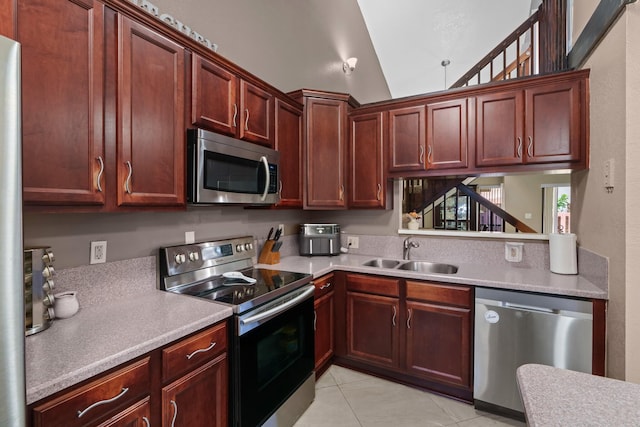 7670 NW 79th Ave Unit O3, Tamarac, FL 33321 - kitchen featuring stainless steel appliances, light tile patterned flooring, light countertops, reddish brown cabinets, and lofted ceiling