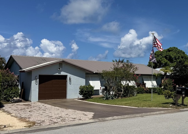 8681 SE Eagle Ave, Hobe Sound, FL 33455 - view of front of home featuring stucco siding, an attached garage, driveway, a front yard, and a metal roof