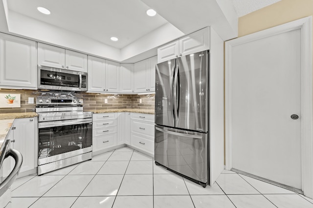 11265 Bannock Ave Unit 5, Boynton Beach, FL 33437 - kitchen featuring appliances with stainless steel finishes, white cabinetry, decorative backsplash, light stone countertops, and light tile patterned floors