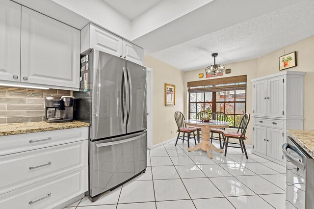 11265 Bannock Ave Unit 5, Boynton Beach, FL 33437 - kitchen with stainless steel appliances, white cabinets, decorative backsplash, light stone counters, and a textured ceiling