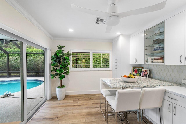 881 Elderberry Way, Boca Raton, FL 33486 - kitchen with healthy amount of natural light, crown molding, white cabinets, light wood-style flooring, and recessed lighting