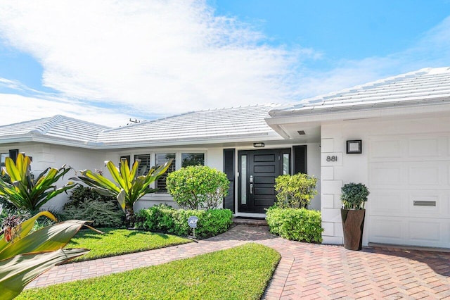881 Elderberry Way, Boca Raton, FL 33486 - view of exterior entry with a tiled roof and an attached garage