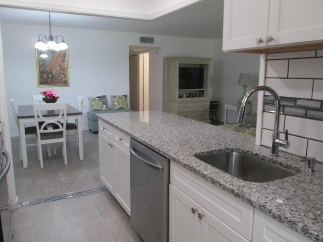 14572 Canalview Dr Unit C, Delray Beach, FL 33484 - kitchen with stainless steel dishwasher, white cabinets, a chandelier, light stone countertops, and hanging light fixtures