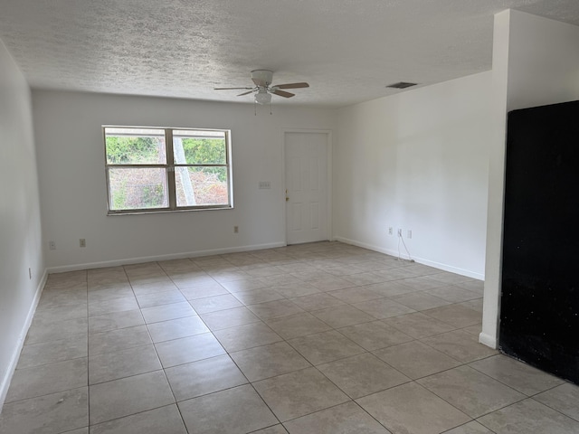 2564 Navajo Ave, Fort Pierce, FL 34946 - empty room with a ceiling fan, a textured ceiling, and light tile patterned flooring