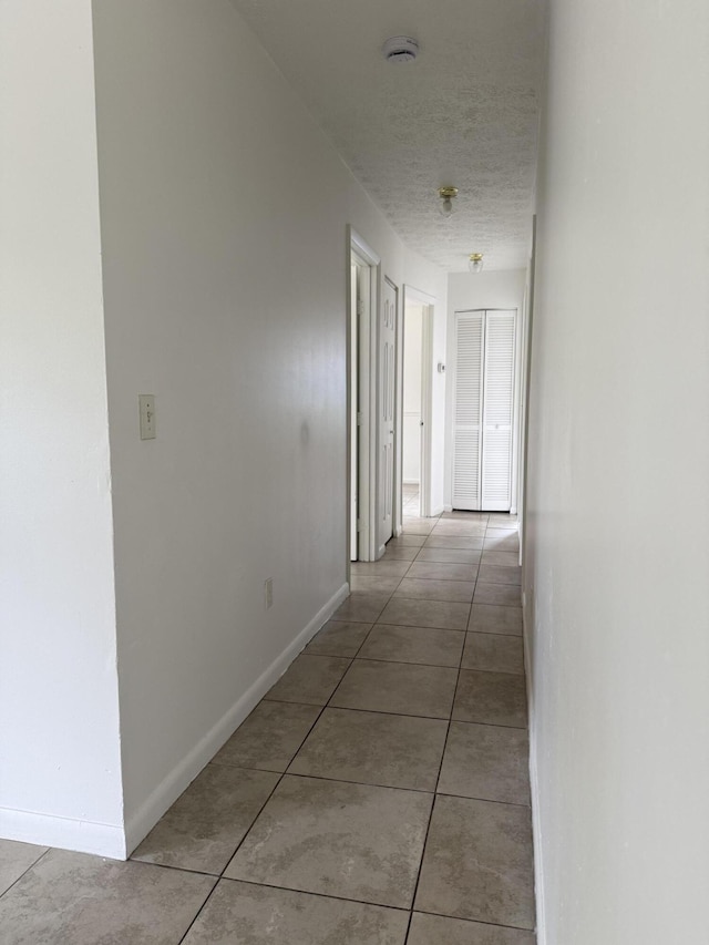 2564 Navajo Ave, Fort Pierce, FL 34946 - hallway with light tile patterned floors and a textured ceiling