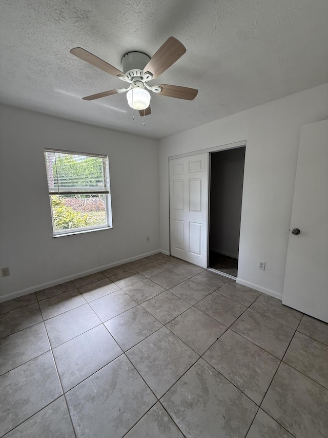 2564 Navajo Ave, Fort Pierce, FL 34946 - unfurnished bedroom featuring a textured ceiling, tile patterned floors, a closet, and ceiling fan
