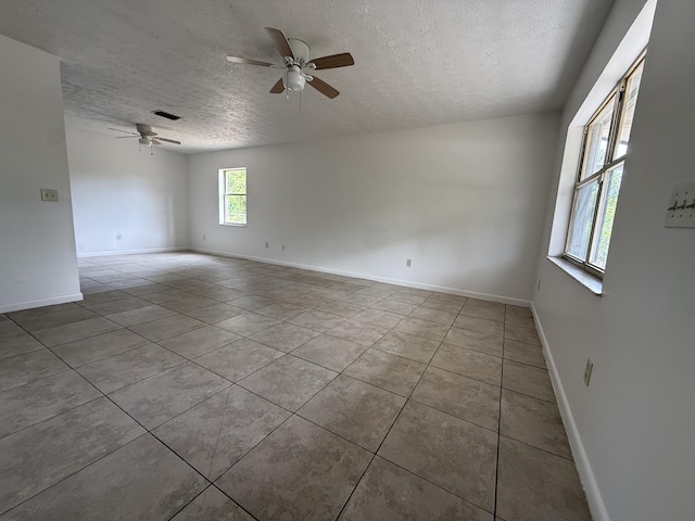 2564 Navajo Ave, Fort Pierce, FL 34946 - spare room with a textured ceiling, a ceiling fan, and tile patterned floors
