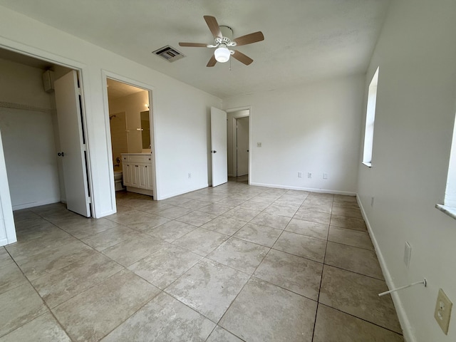 2564 Navajo Ave, Fort Pierce, FL 34946 - unfurnished bedroom with light tile patterned flooring, a closet, a spacious closet, connected bathroom, and ceiling fan