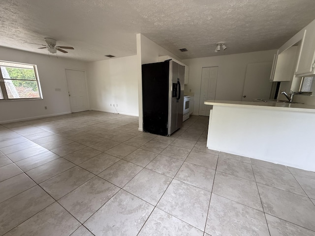 2564 Navajo Ave, Fort Pierce, FL 34946 - kitchen featuring stainless steel fridge, a textured ceiling, white range, a ceiling fan, and light tile patterned floors