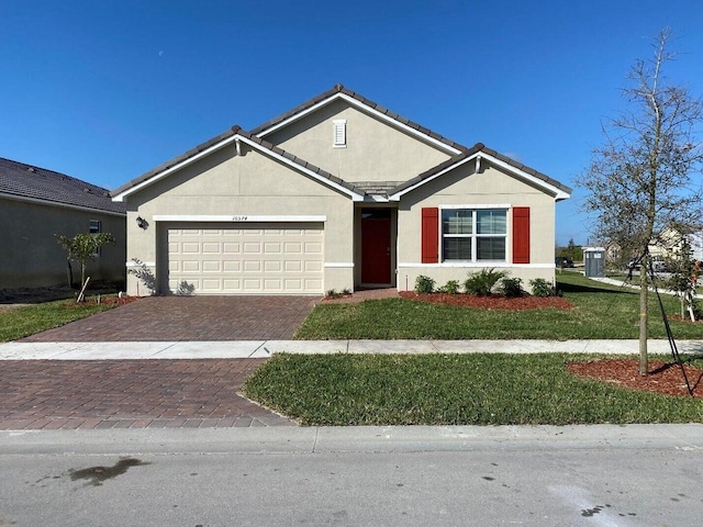 10574 SW Jem St, Port Saint Lucie, FL 34987 - ranch-style home with an attached garage, stucco siding, decorative driveway, a front yard, and a tile roof