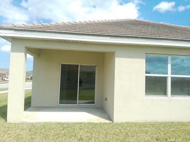 10574 SW Jem St, Port Saint Lucie, FL 34987 - back of house with a patio, stucco siding, a tile roof, and a lawn