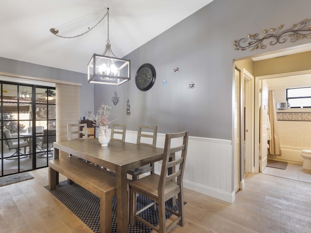 1155 Woodcrest Rd W, West Palm Beach, FL 33417 - dining room with light wood finished floors, wainscoting, a chandelier, and lofted ceiling