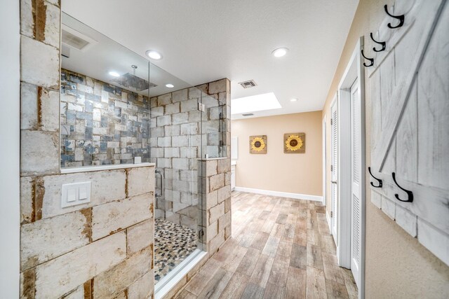 1819 SW Crane Crk, Palm City, FL 34990 - bathroom with a stall shower, wood finished floors, a skylight, and recessed lighting