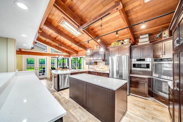 1819 SW Crane Crk, Palm City, FL 34990 - kitchen with wood ceiling, appliances with stainless steel finishes, a peninsula, rail lighting, and light wood-style floors