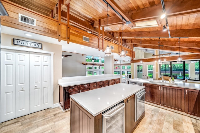1819 SW Crane Crk, Palm City, FL 34990 - kitchen featuring a wooden ceiling with exposed beams, a center island, light wood-style flooring, light countertops, and rail lighting