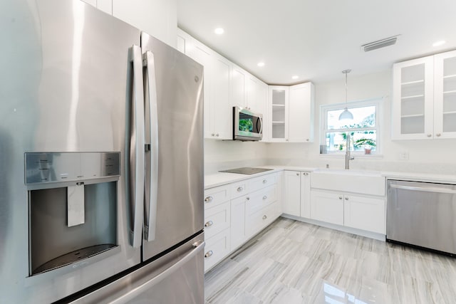 450 NE 38th St, Boca Raton, FL 33431 - kitchen with stainless steel appliances, light countertops, glass insert cabinets, decorative light fixtures, and white cabinets