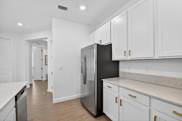 14929 Three Ponds Trl, Delray Beach, FL 33446 - kitchen featuring appliances with stainless steel finishes, white cabinetry, light wood-style flooring, light stone counters, and recessed lighting