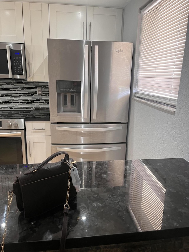 9467 Boca Cove Cir Unit 804, Boca Raton, FL 33428 - kitchen with stainless steel appliances, white cabinetry, decorative backsplash, and dark stone counters