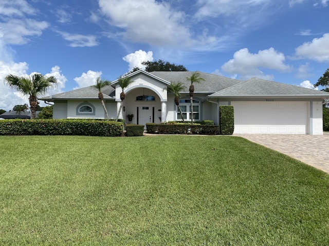 3053 SE Darien Rd, Port Saint Lucie, FL 34952 - single story home featuring a garage, a front lawn, decorative driveway, and stucco siding