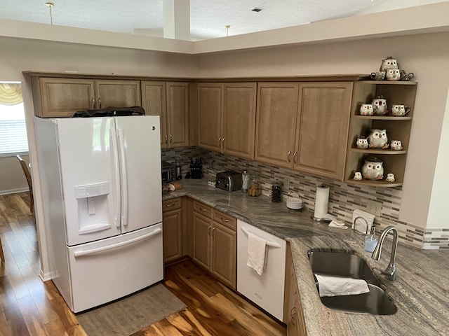 3053 SE Darien Rd, Port Saint Lucie, FL 34952 - kitchen with white appliances, tasteful backsplash, wood finished floors, stone countertops, and a textured ceiling