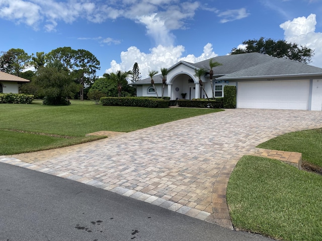 3053 SE Darien Rd, Port Saint Lucie, FL 34952 - ranch-style house with a front yard, a garage, driveway, and stucco siding