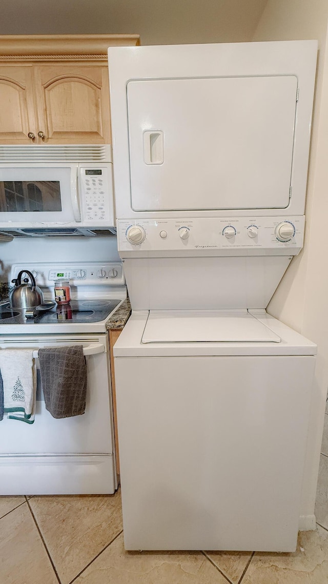 4090 Tivoli Ct Unit 303, Lake Worth, FL 33467 - washroom featuring stacked washer and clothes dryer and light tile patterned floors
